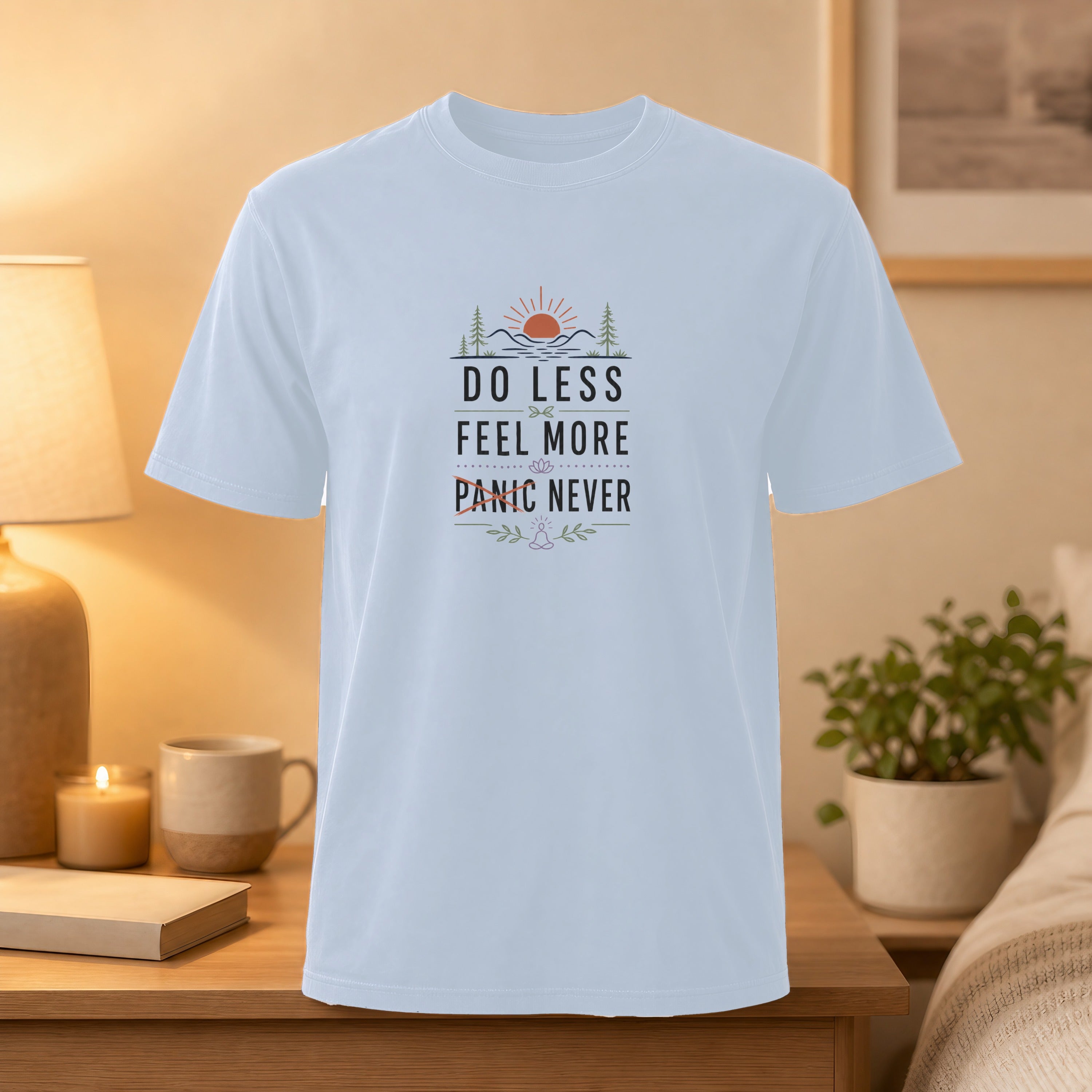 Light blue t-shirt with text "DO LESS FEEL MORE PANIC NEVER" and a mountain sunset graphic.