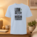 Light blue t-shirt with "LOW BATTERY, HIGH STANDARDS" text.