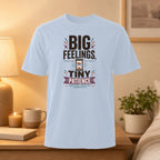 Light blue t-shirt with "BIG FEELINGS, TINY PATIENCE" text and hourglass graphic.