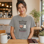 Woman wearing gray t-shirt with "My Nervous System Needs A Manager" text and brain graphic.