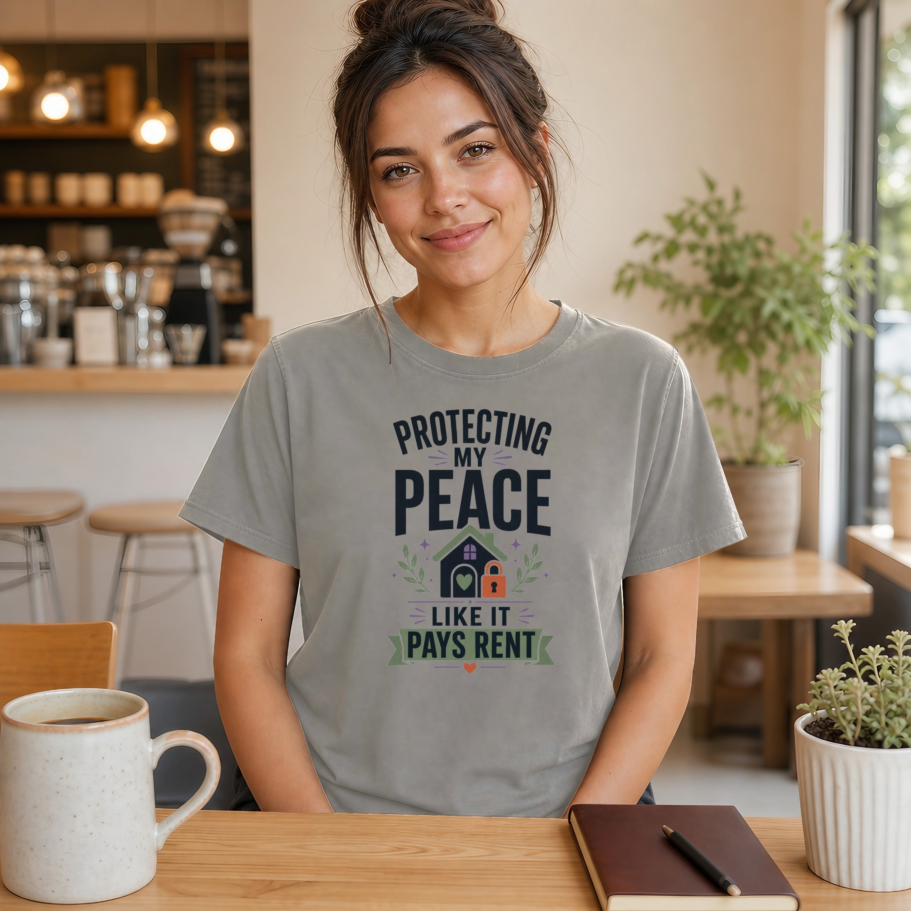 Woman wearing a gray t-shirt that says "Protecting my peace like it pays rent".