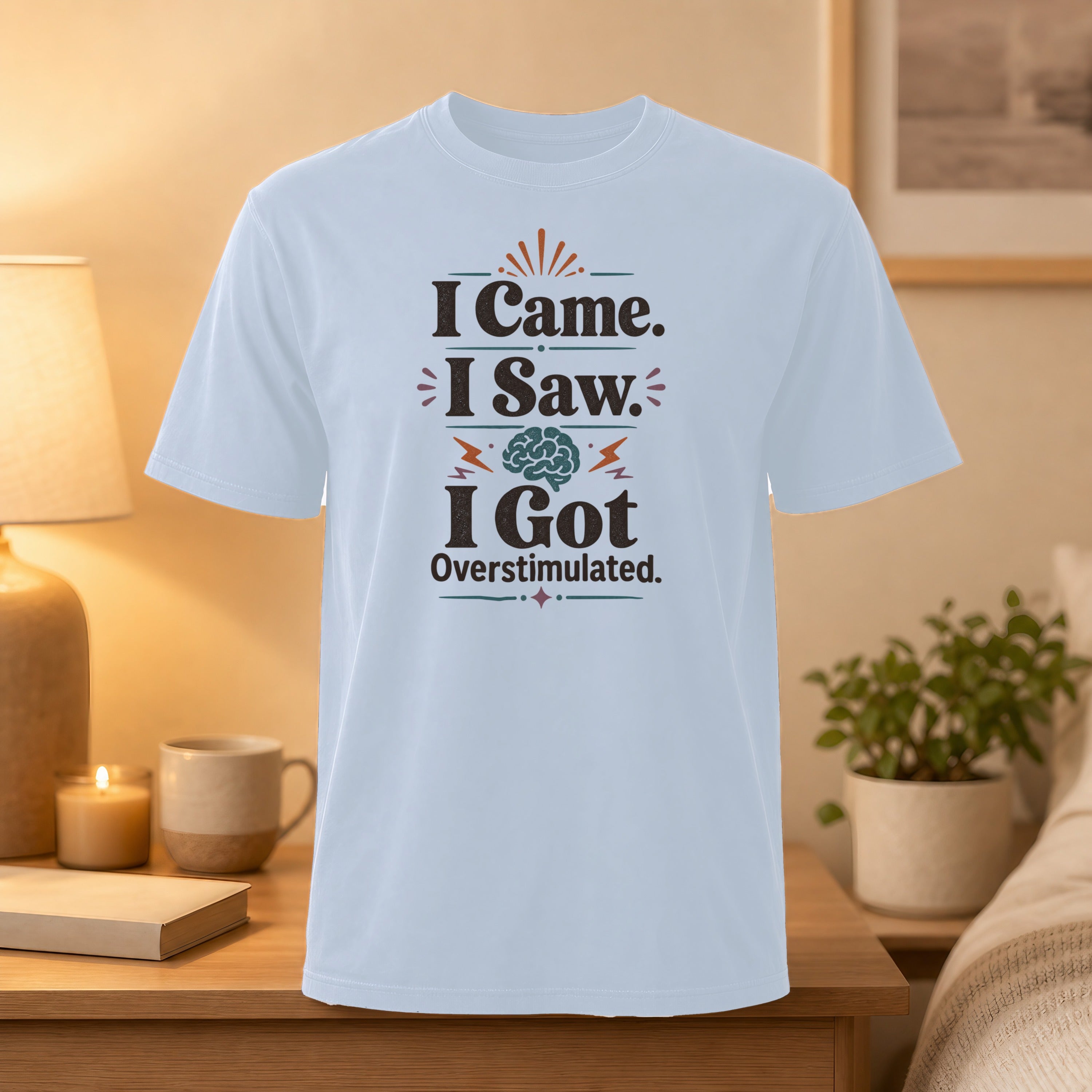 Light blue t-shirt with text "I Came. I Saw. I Got Overstimulated." and a brain graphic.