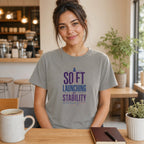 Woman wearing a grey t-shirt with "SO FI LAUNCHING MY STABILITY" text.