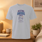 White t-shirt with "Resting Anxious Face" graphic and text.