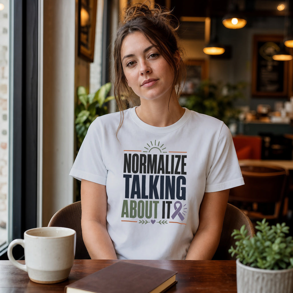 Woman in white t-shirt with text "Normalize Talking About It" and purple ribbon graphic.