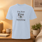 Light blue t-shirt with "I'm Fine But My Eye Is Twitching" text and eye graphic.