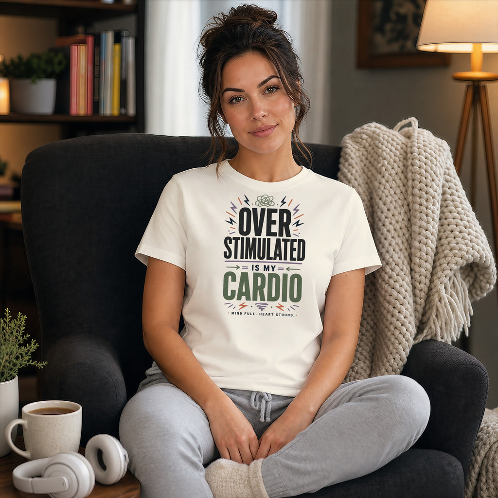 Woman wearing a white t-shirt that says "Over stimulated is my cardio" sitting in a chair.