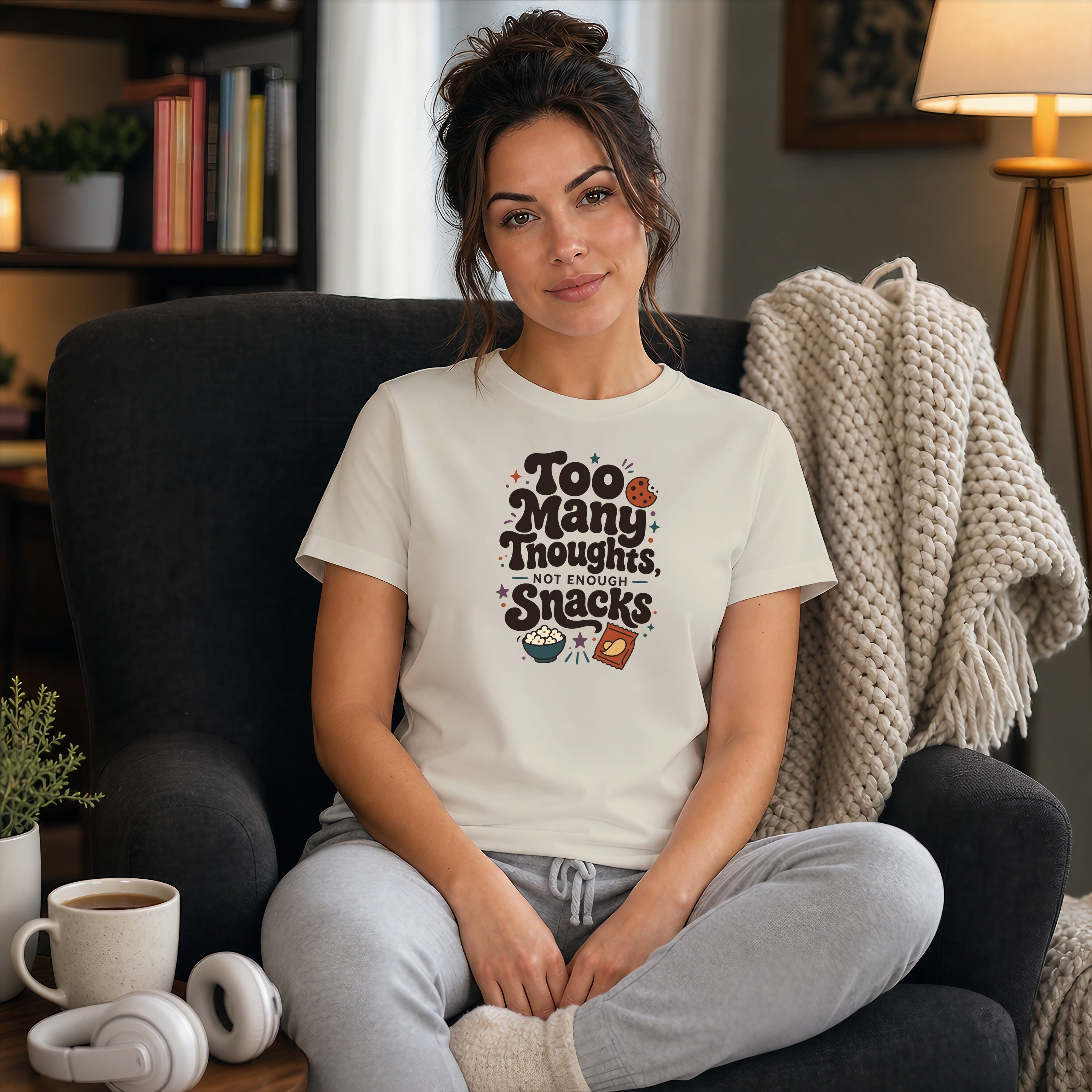 Woman in a cream t-shirt with "Too Many Thoughts Not Enough Snacks" text.
