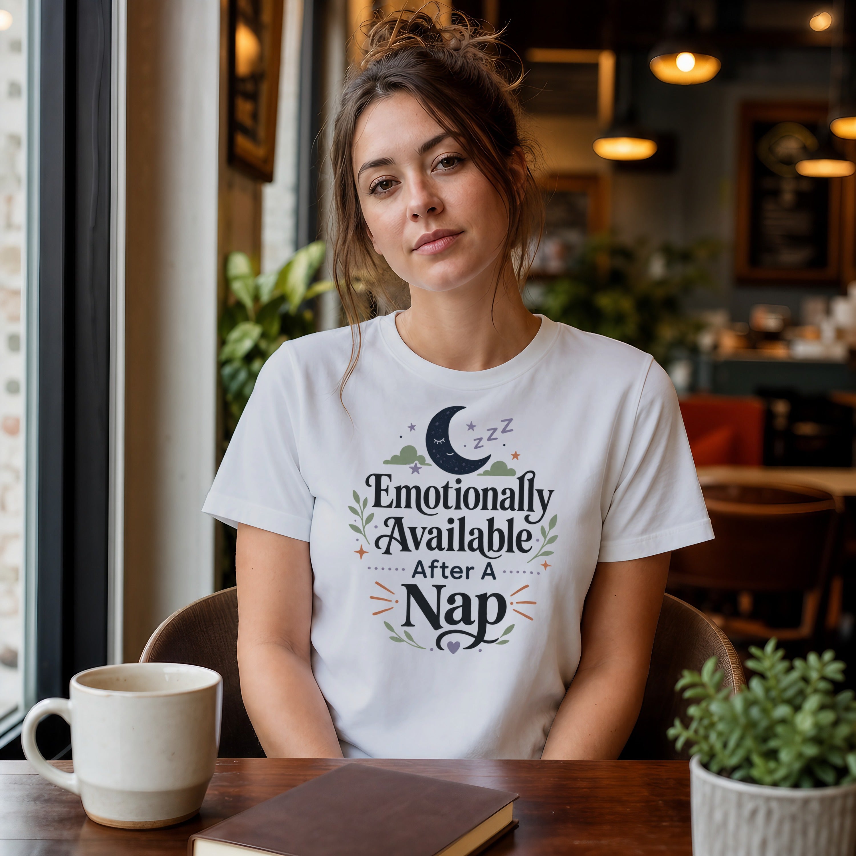 Woman wearing a white t-shirt with "Emotionally Available After a Nap" text.