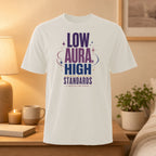 White t-shirt with "LOW AURA HIGH STANDARDS" and "I PROTECT MY PEACE" text.