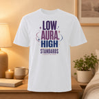 White t-shirt with "LOW AURA HIGH STANDARDS I PROTECT MY PEACE" text.
