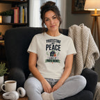 Woman in armchair wearing t-shirt that reads "Protecting My Peace Like It Pays Rent".