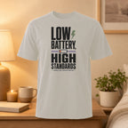 White t-shirt with "LOW BATTERY, HIGH STANDARDS" text and lightning bolt graphic.