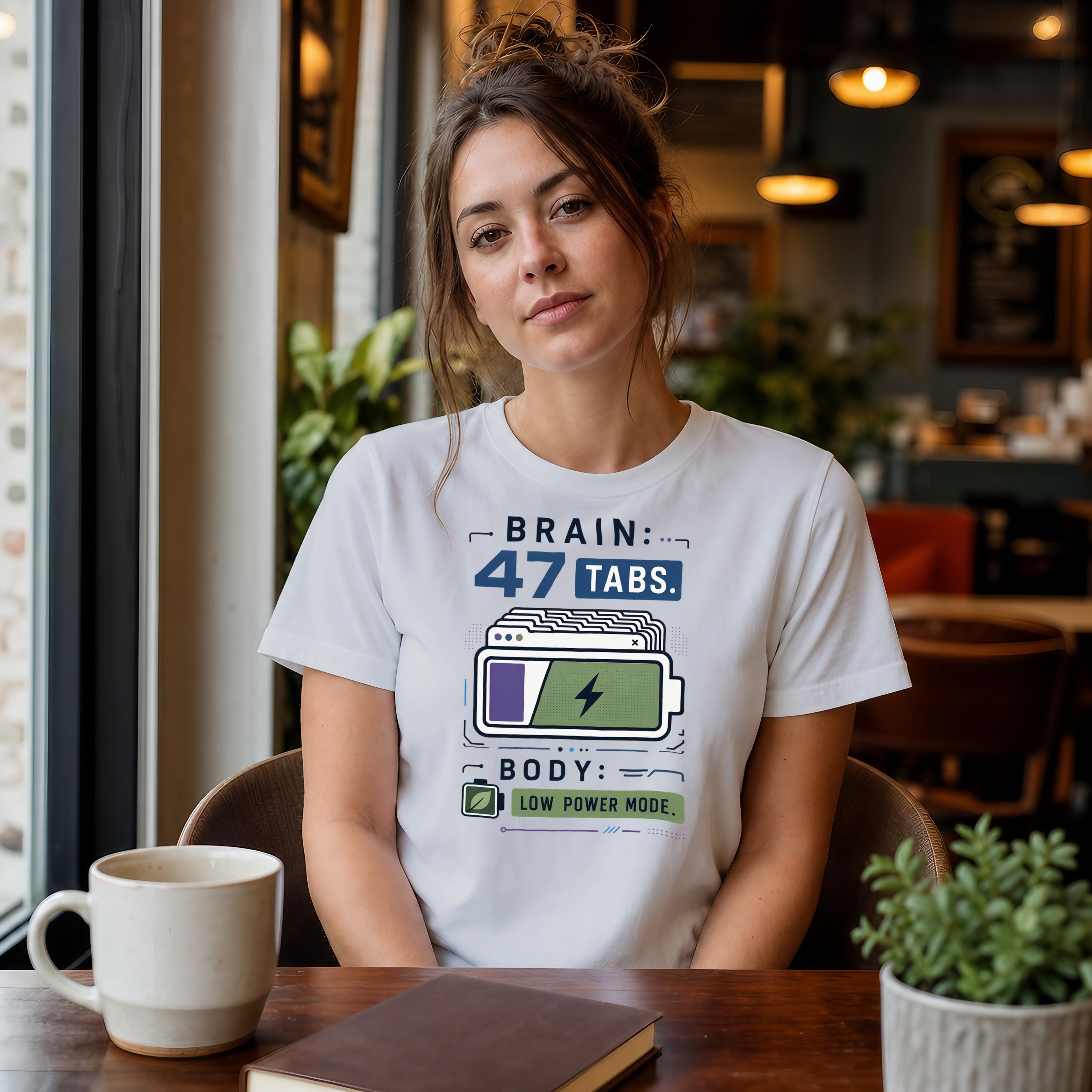 Woman wearing white t-shirt with "BRAIN: 47 TABS. BODY: LOW POWER MODE." graphic.