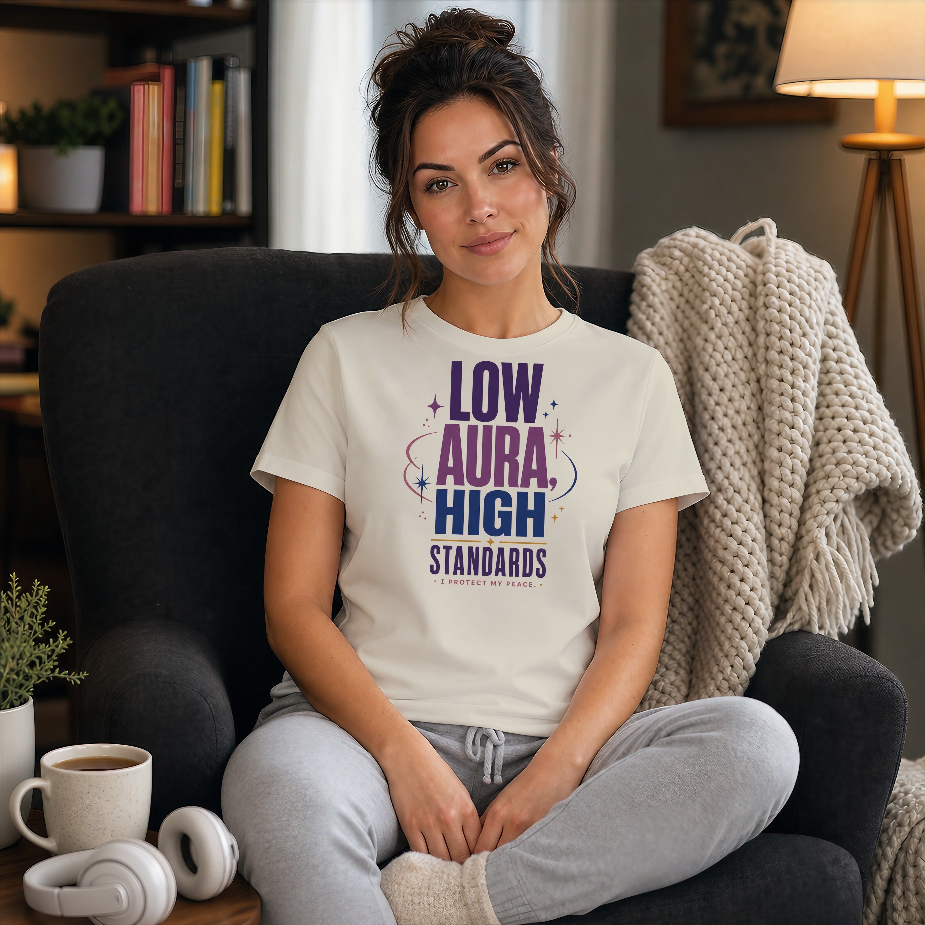 Woman wearing a t-shirt that says "LOW AURA HIGH STANDARDS".