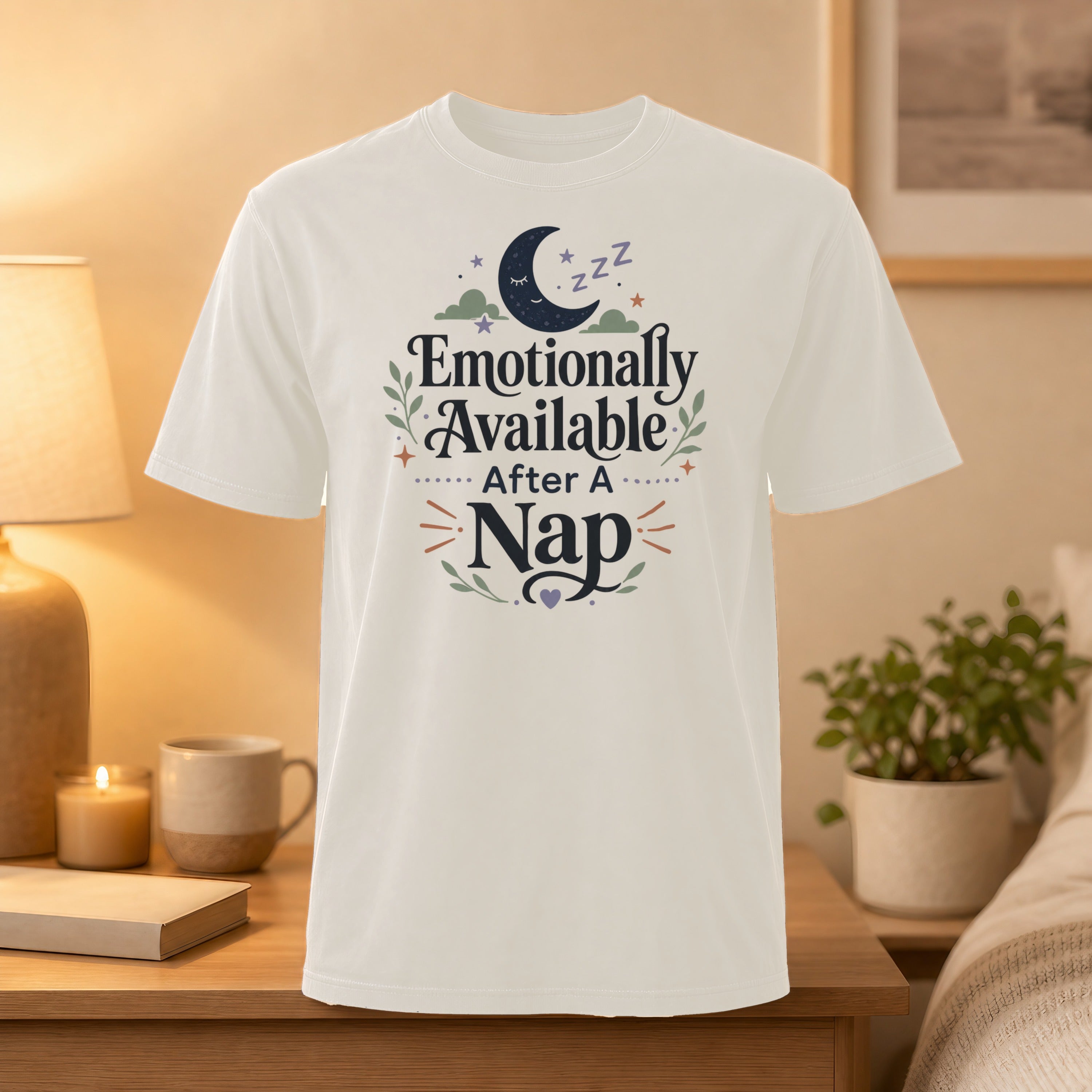 White t-shirt with "Emotionally Available After A Nap" text and moon graphic.