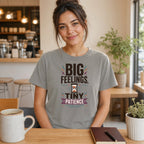 Woman in gray t-shirt with "BIG FEELINGS, TINY PATIENCE" text.