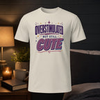 White t-shirt with "OVERSTIMULATED BUT STILL CUTE" text.