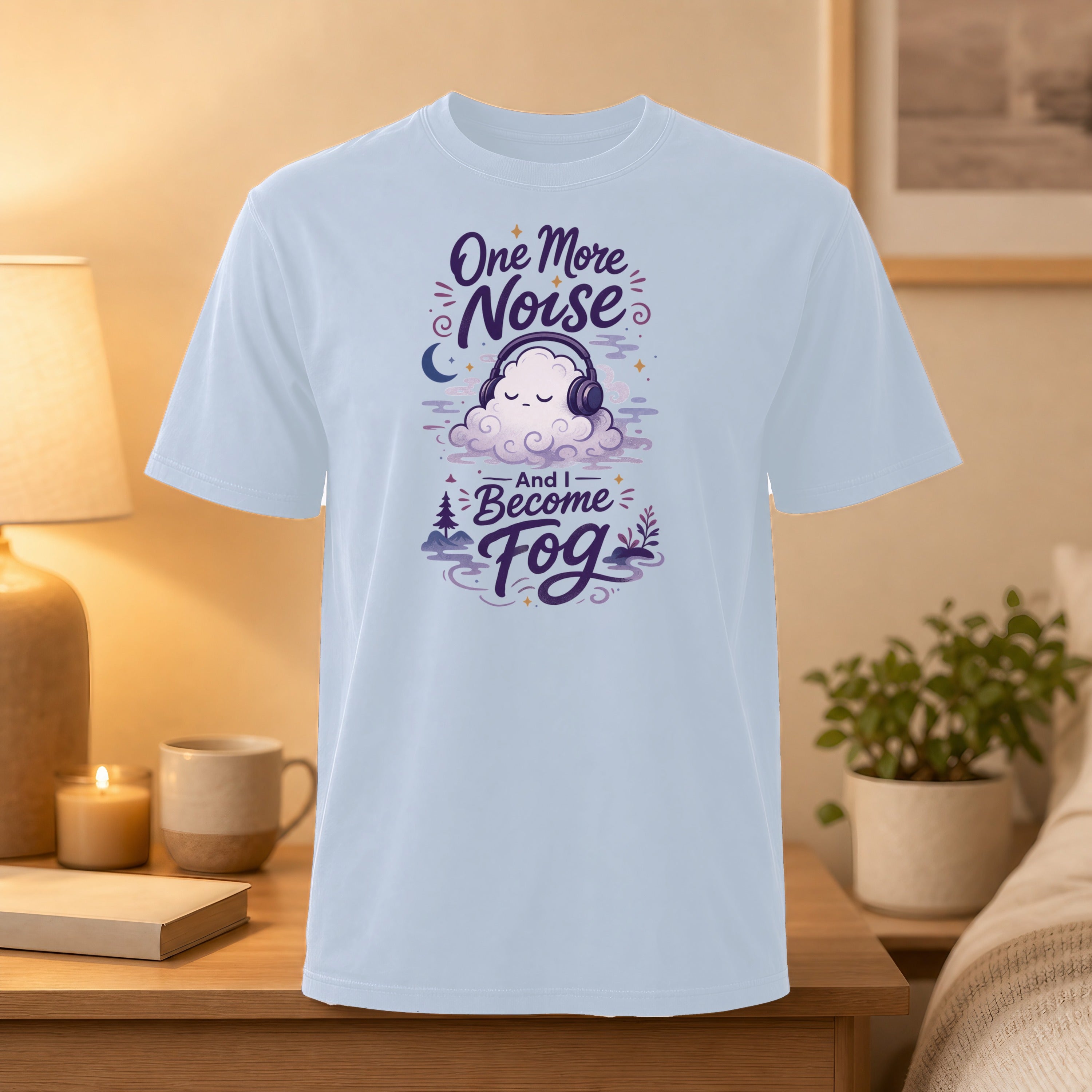 Light blue t-shirt with a cartoon cloud wearing headphones and text "One More Noise And I Become Fog".