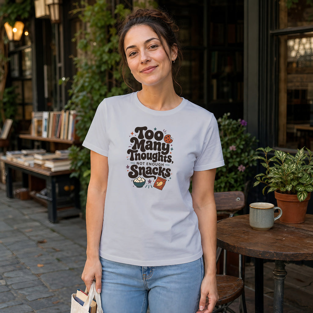 Woman wearing white t-shirt with "Too Many Thoughts, Not Enough Snacks" text and snack graphics.
