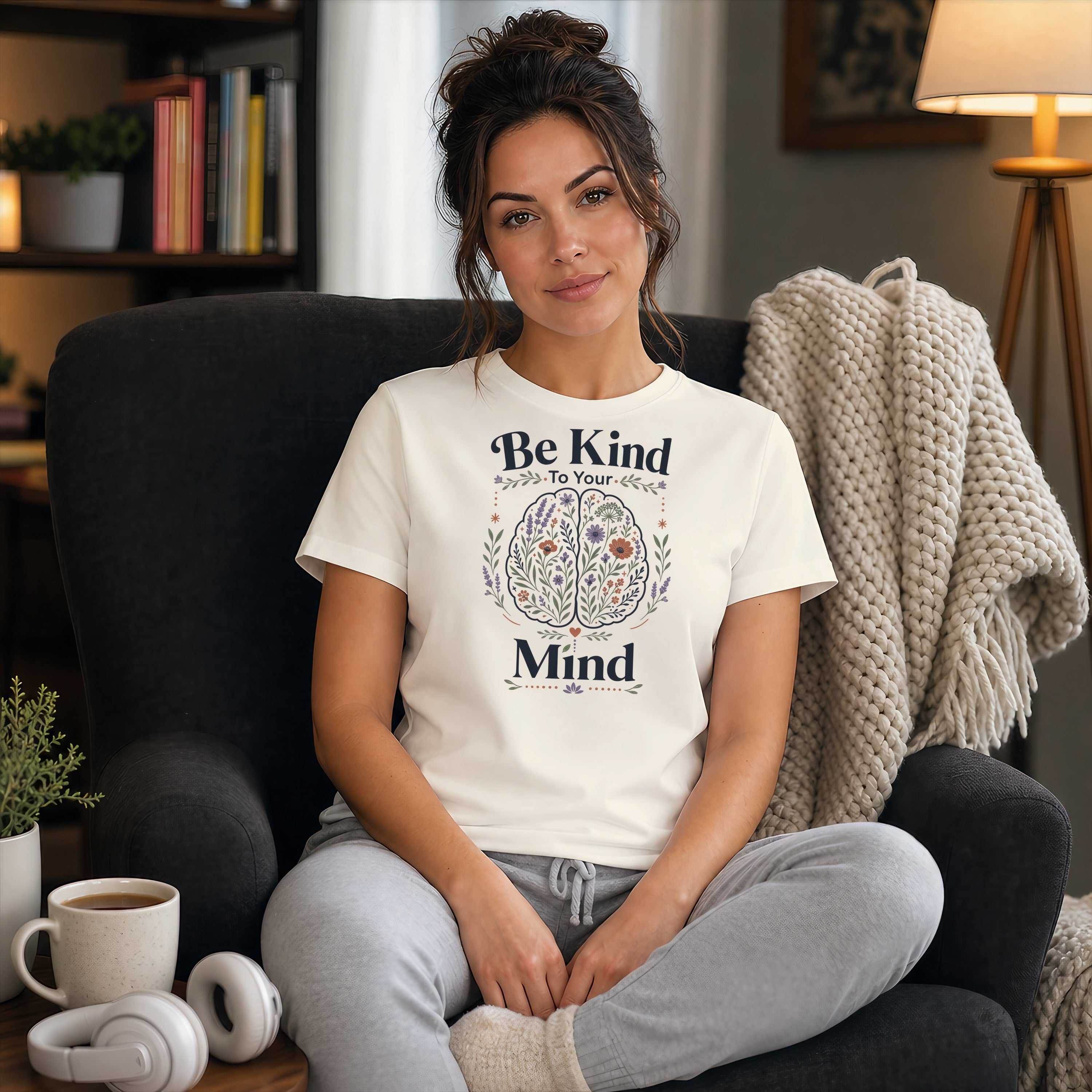 Woman wearing t-shirt with "Be Kind To Your Mind" text and floral brain design.