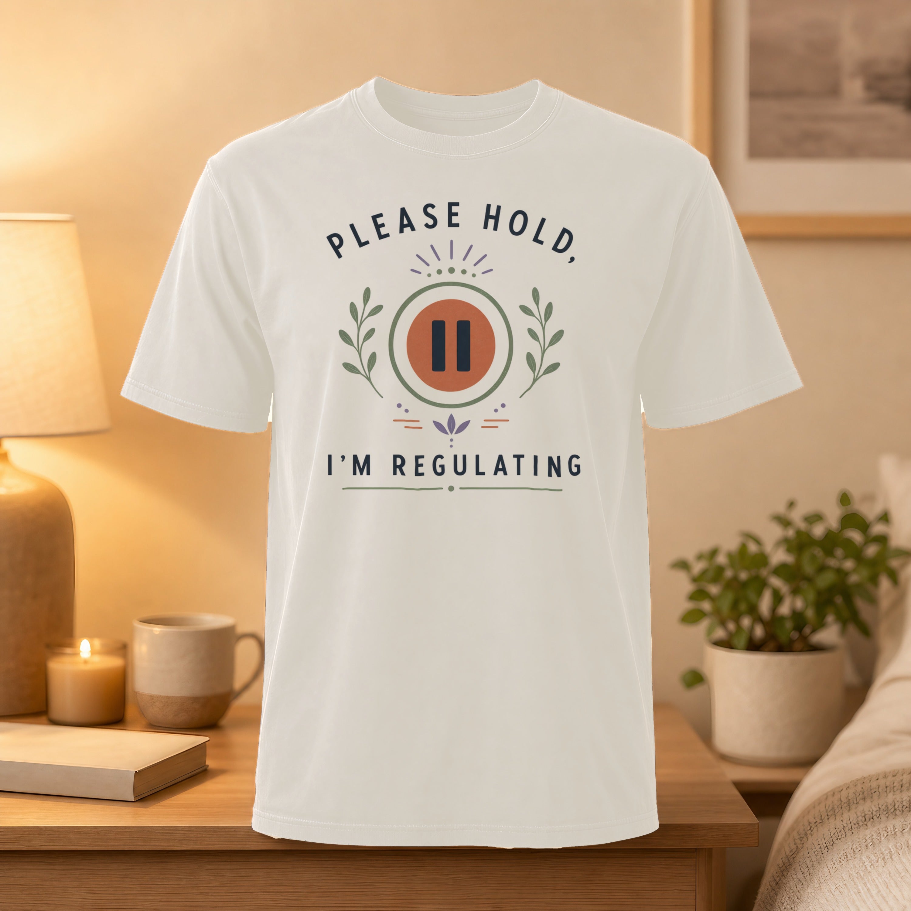 White t-shirt with "PLEASE HOLD, I'M REGULATING" text and pause symbol.