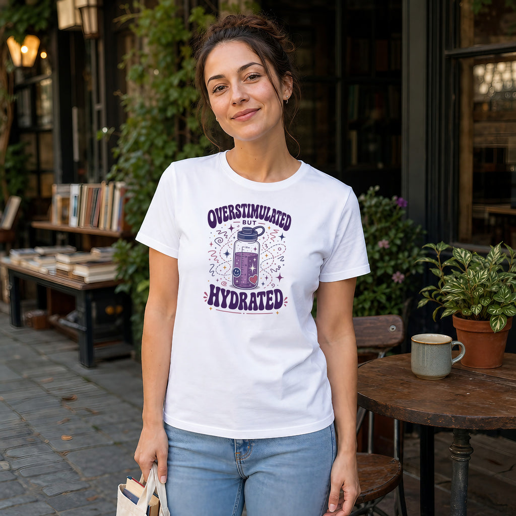 Woman wearing white t-shirt with "Overstimulated but Hydrated" graphic.