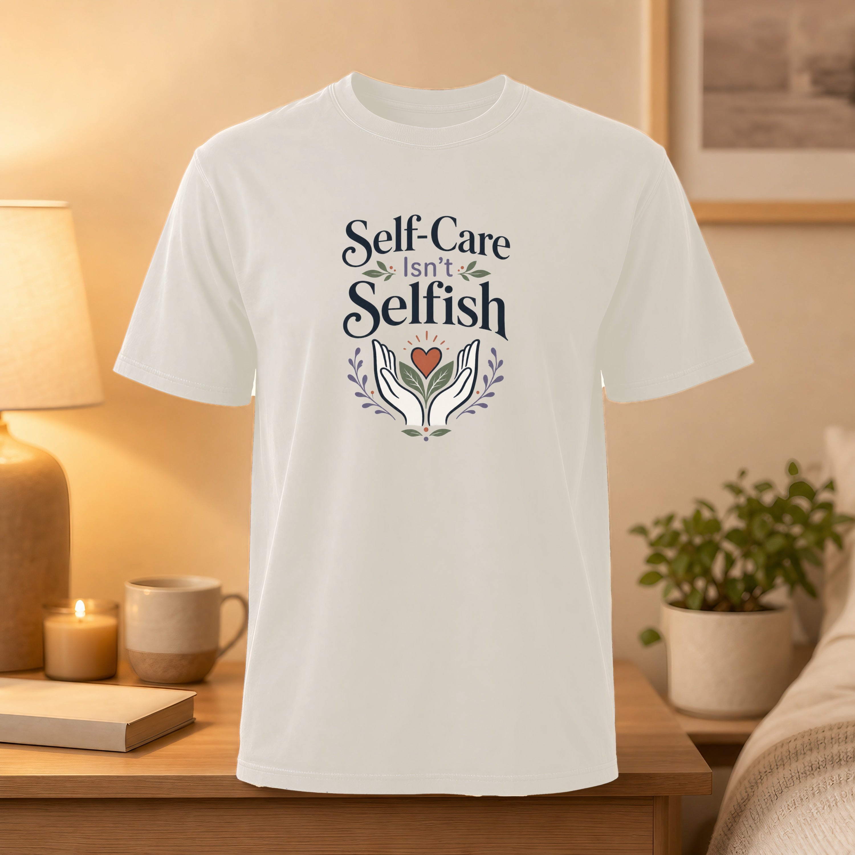 White t-shirt with "Self-Care Isn't Selfish" text and hands holding plant.