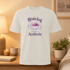 White t-shirt with "Brain Fog But Make It Aesthetic" text and cloud illustration.