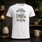 White t-shirt with "I'm Not Ignoring You, I'm Recharging" graphic.
