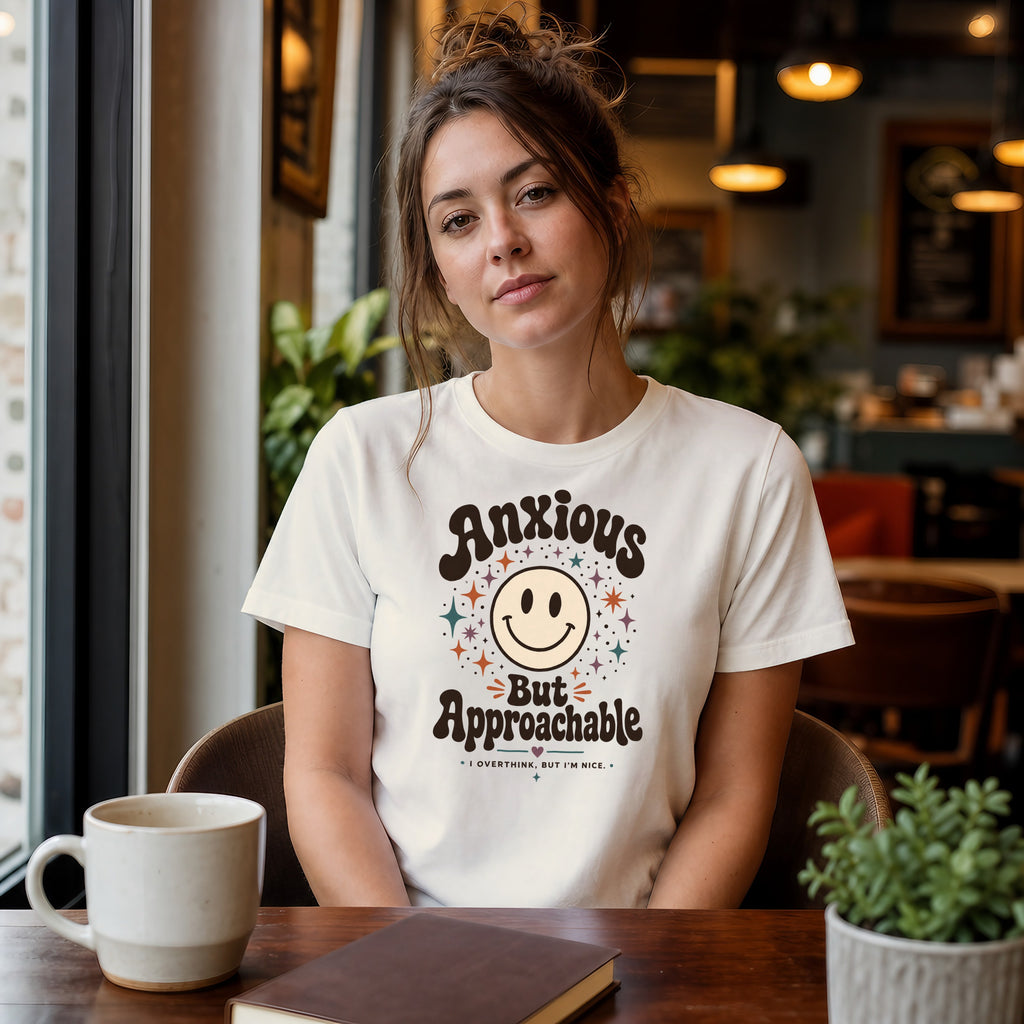Woman wearing a t-shirt with "Anxious But Approachable" text and smiley face design.