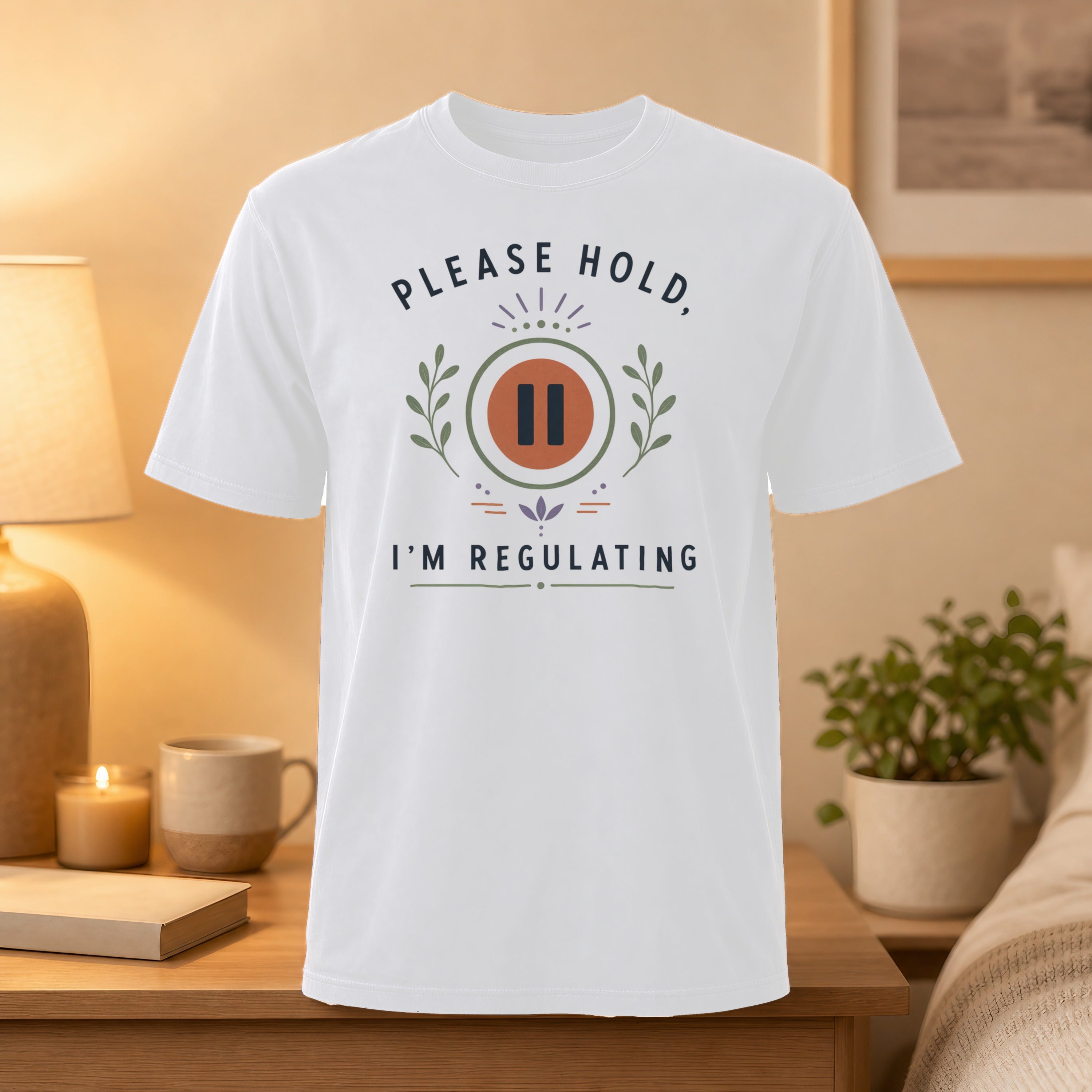 White t-shirt with "PLEASE HOLD I'M REGULATING" text and pause symbol.