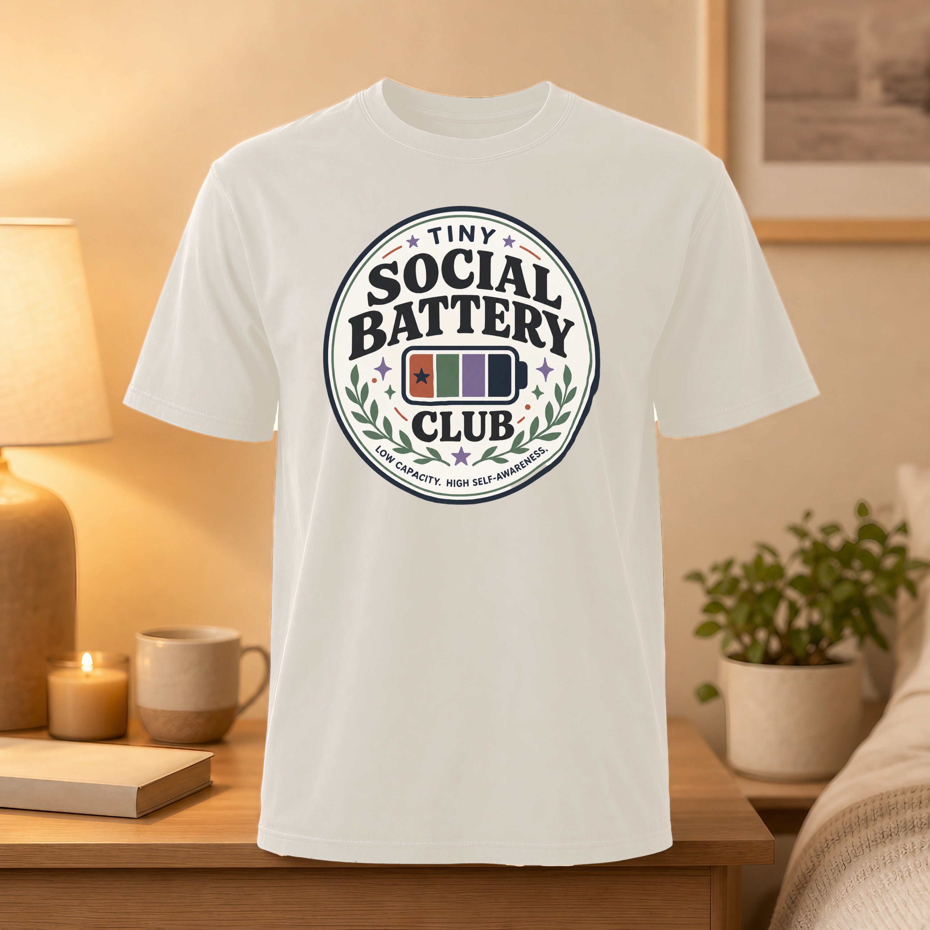 White t-shirt with "Tiny Social Battery Club" circular logo.