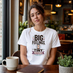 Woman wearing white t-shirt with "BIG FEELINGS, TINY PATIENCE" text.