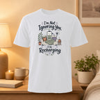 White t-shirt with "I'm Not Ignoring You, I'm Recharging" text and battery graphic.