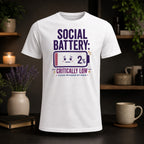 White t-shirt with "SOCIAL BATTERY: CRITICALLY LOW 2%" graphic.