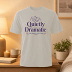 White t-shirt with "Quietly Dramatic" text and theater masks graphic.