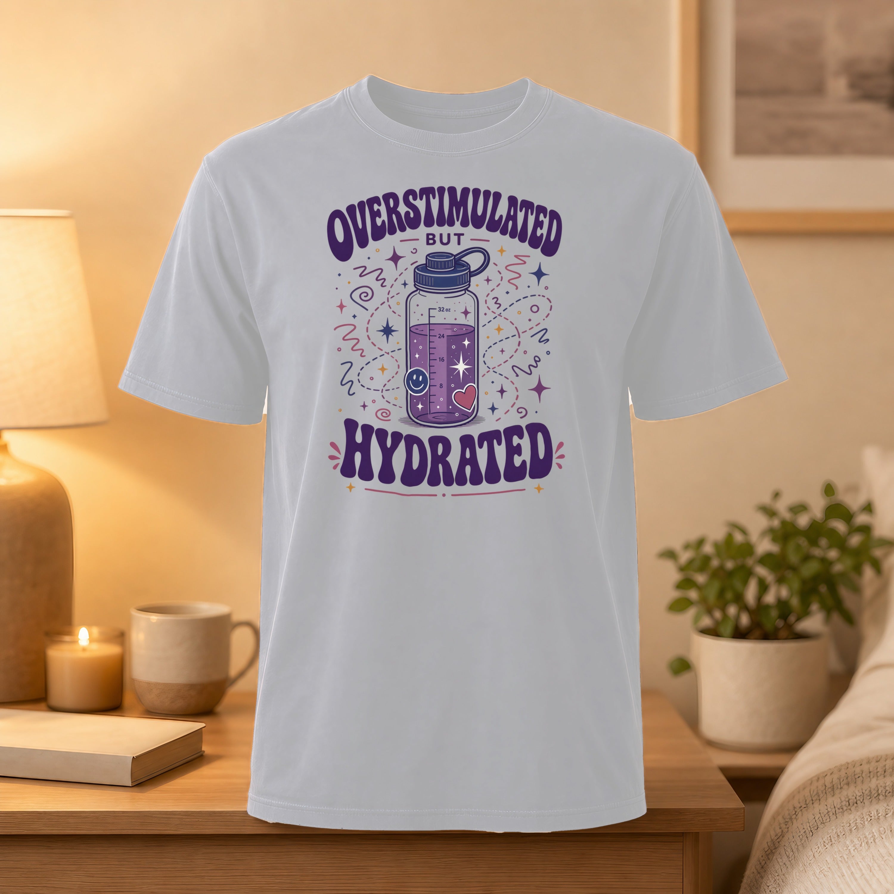White t-shirt with "Overstimulated but Hydrated" graphic featuring a water bottle and stars.