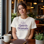 Woman in cream t-shirt with "Quietly Dramatic" text and theater masks.