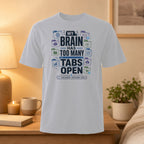 White t-shirt with text "My brain has too many tabs open" and icons.