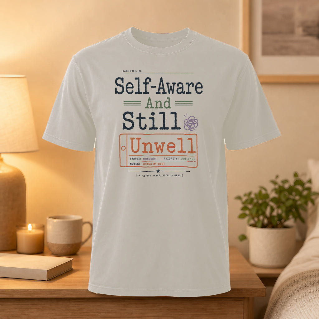 White t-shirt with "Self-Aware And Still Unwell" text and case file details.