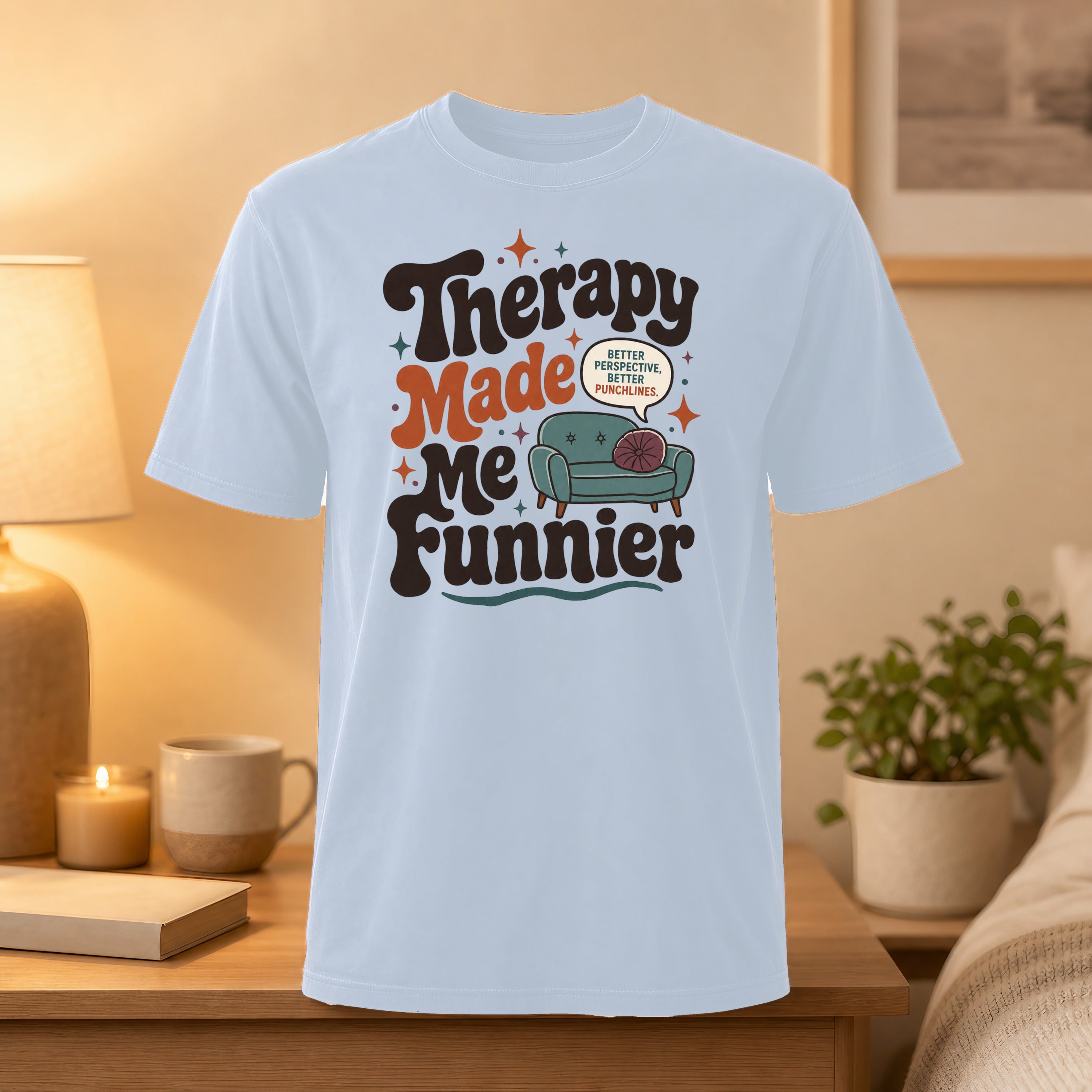 Light blue t-shirt with text "Therapy Made Me Funnier" and couch graphic.