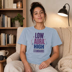 Light blue t-shirt with text "LOW AURA HIGH STANDARDS" and stars.
