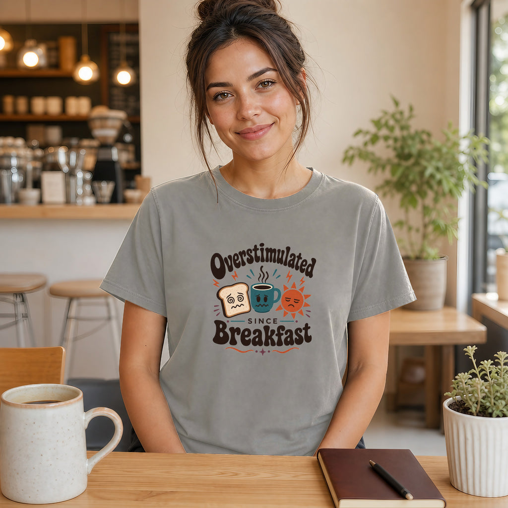Woman wearing a t-shirt with "Overstimulated Since Breakfast" graphic.