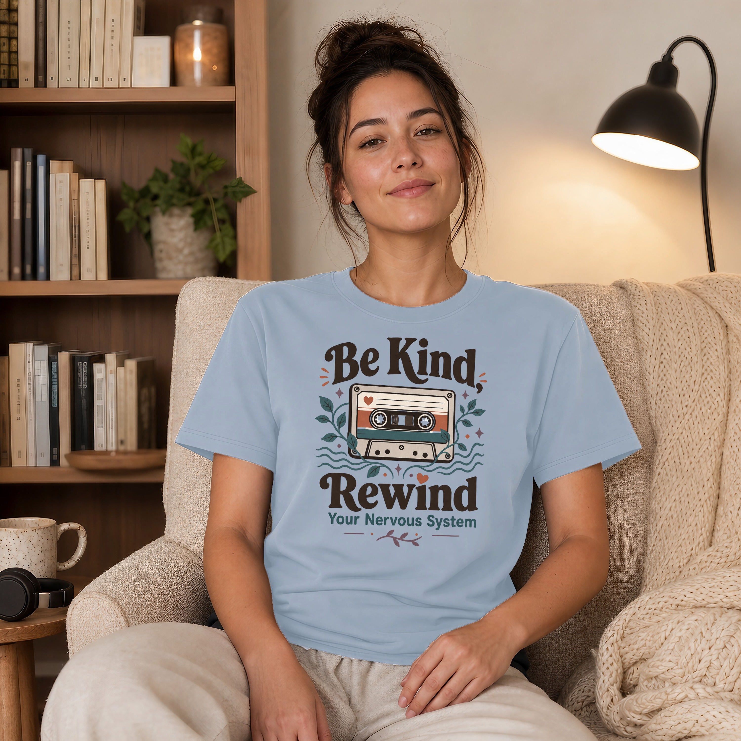 Light blue t-shirt with "Be Kind, Rewind Your Nervous System" and cassette tape graphic.