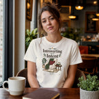 Woman wearing a white t-shirt with "Introverting With Intent" text and cozy illustration.