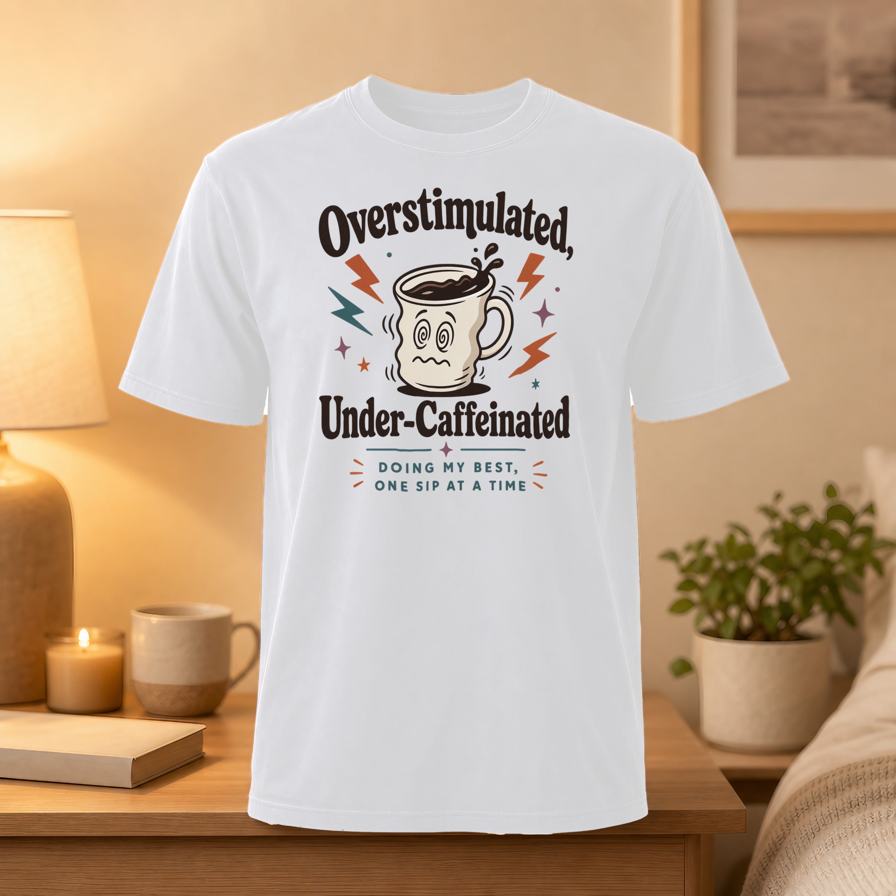 White t-shirt with "Overstimulated, Under-Caffeinated" and lightning bolt coffee mug graphic.