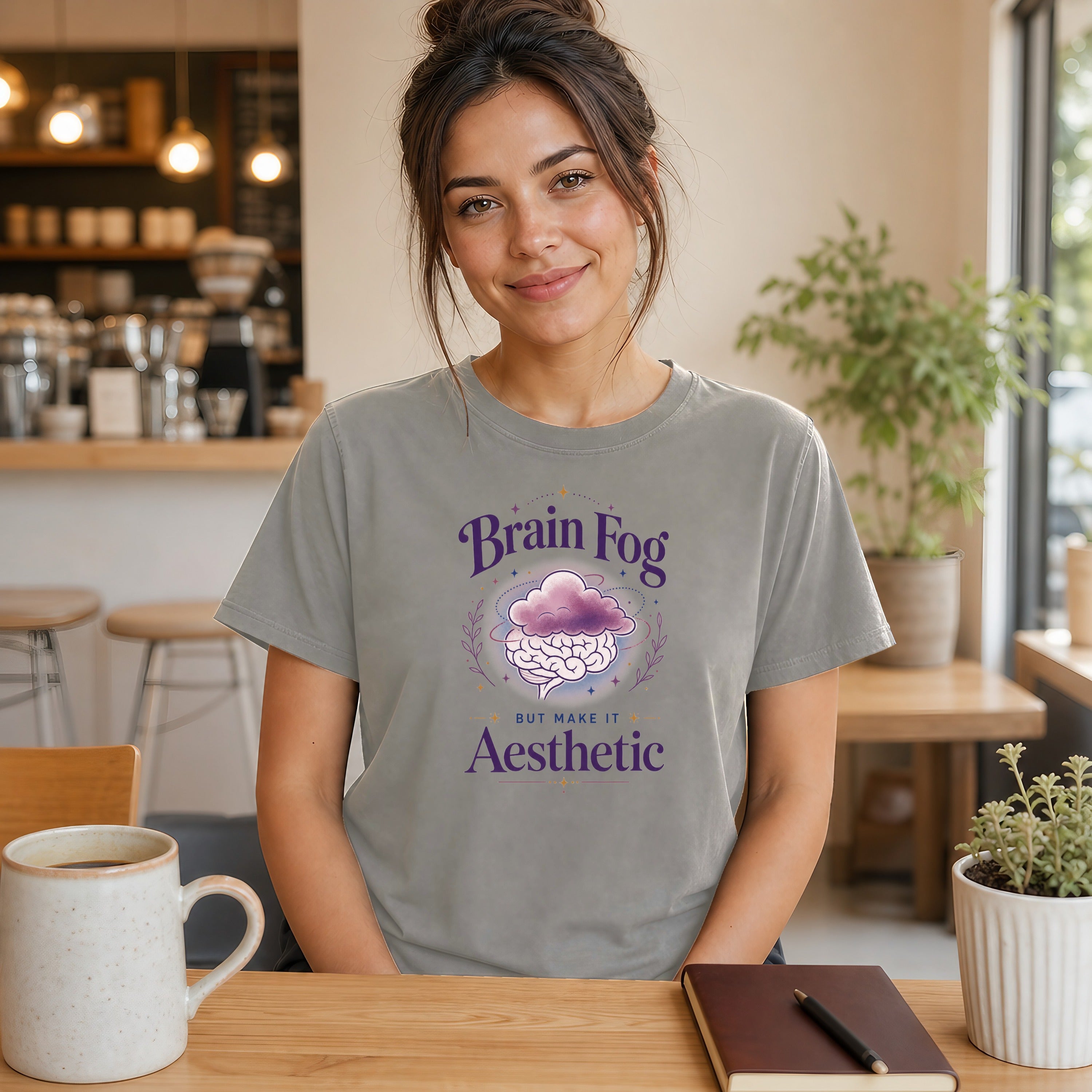 Woman wearing grey t-shirt with "Brain Fog Aesthetic" text and cloud design.