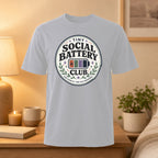 Light gray t-shirt with "Tiny Social Battery" logo and "Low Capacity, High Self-Awareness."
