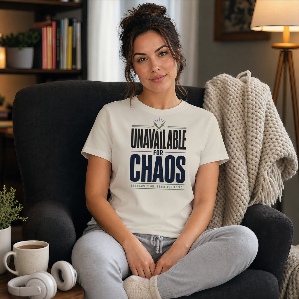 Woman in t-shirt reading "Unavailable for Chaos" sitting in chair.
